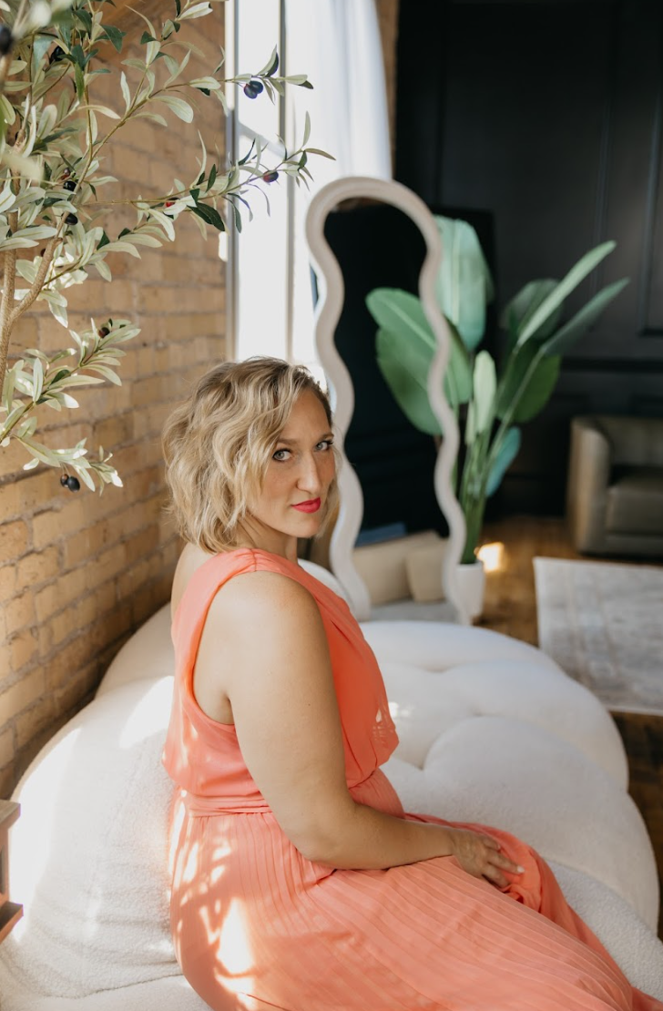 Dr. Mel Krug reading on a velvet couch — Project Lioness Community for alumni